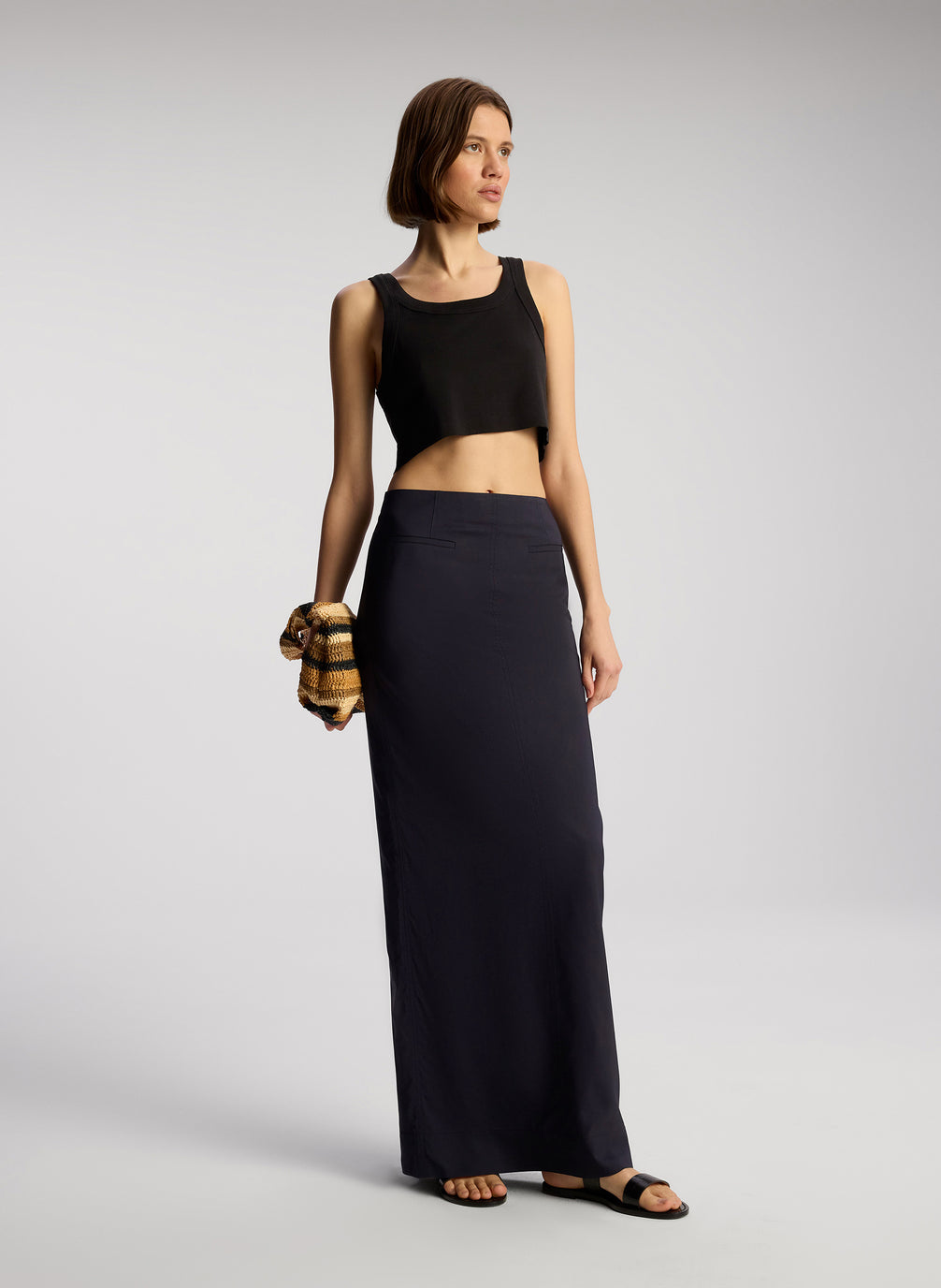 front view of woman wearing black cropped rib tank top with black maxi skirt