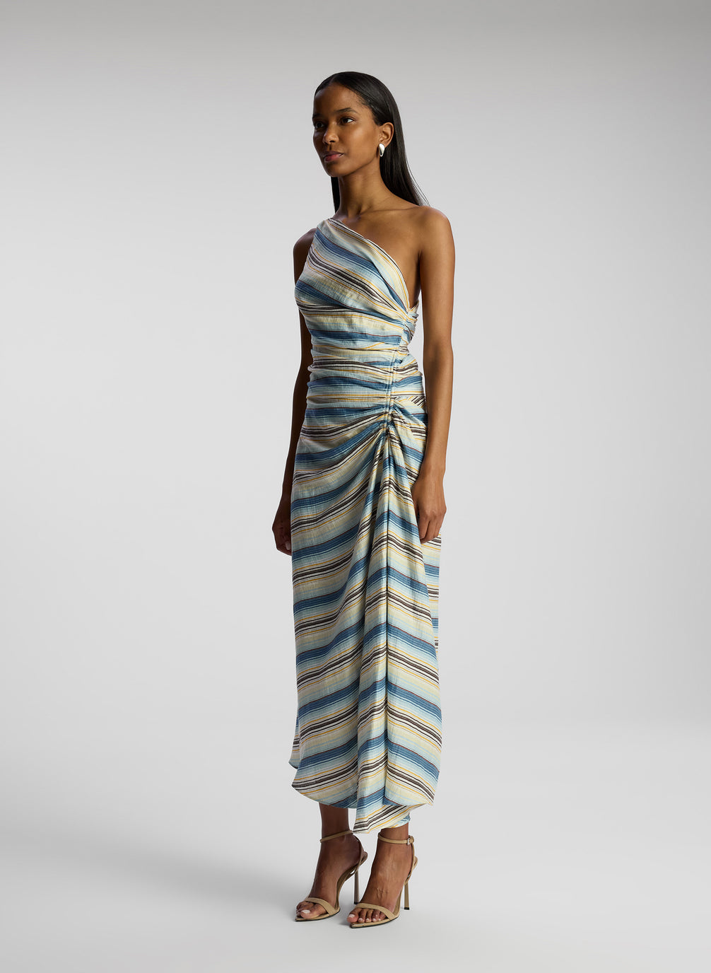 side view of woman wearing one shoulder striped midi dress