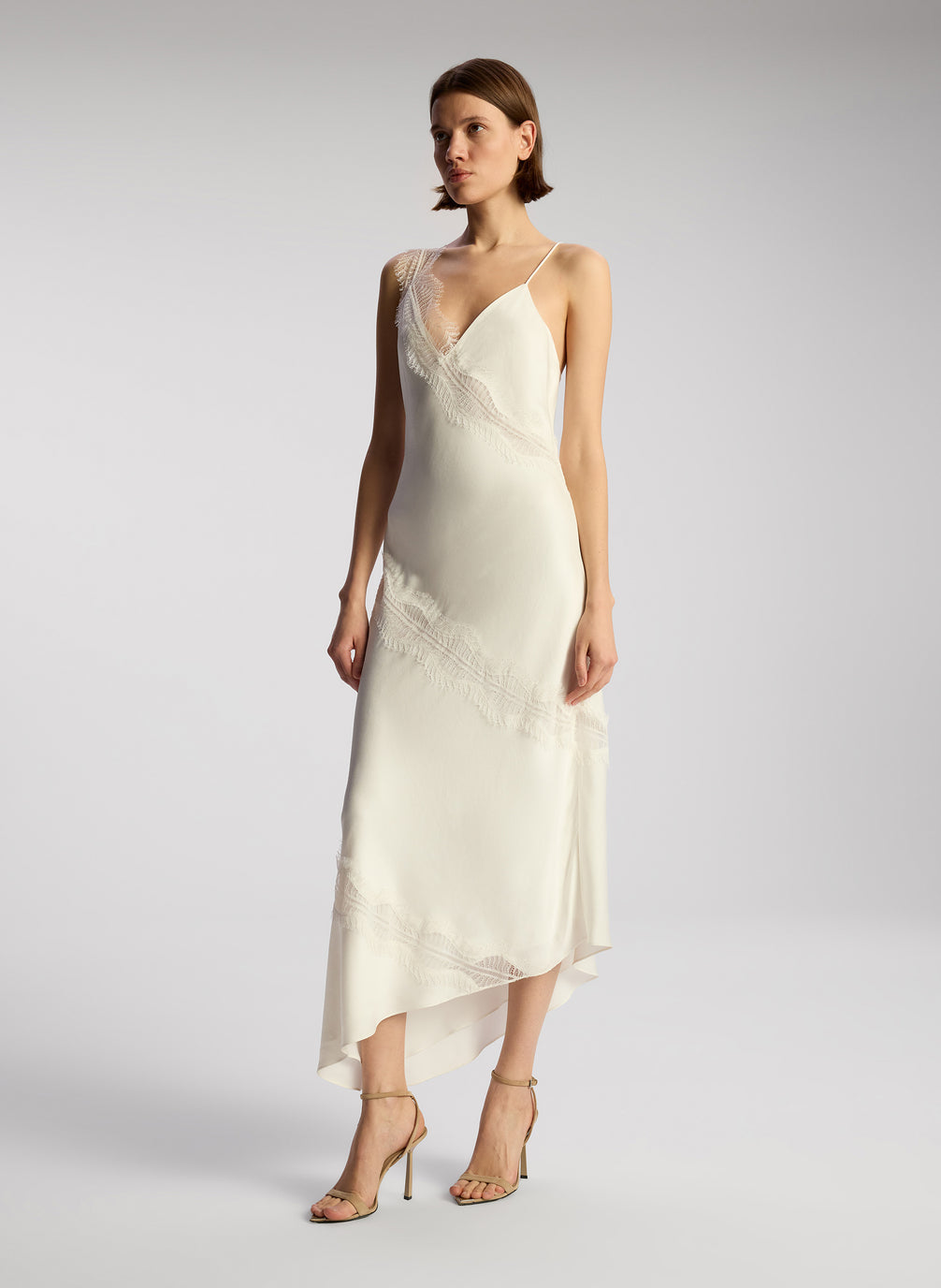 side view of woman wearing off white lace trimmed midi dress