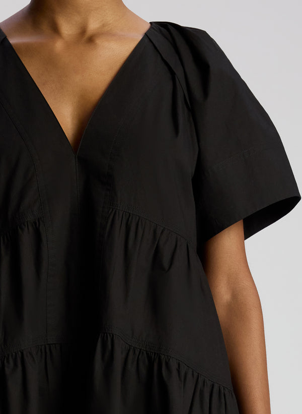 detail view of woman wearing black short sleeve mini dress
