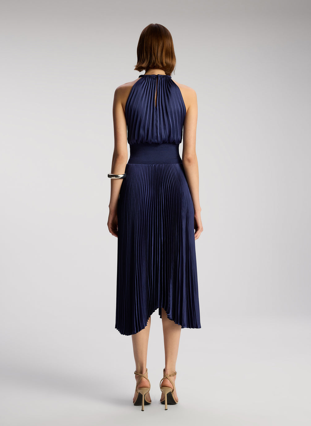 back view of woman wearing navy blue sleeveless pleated midi dress
