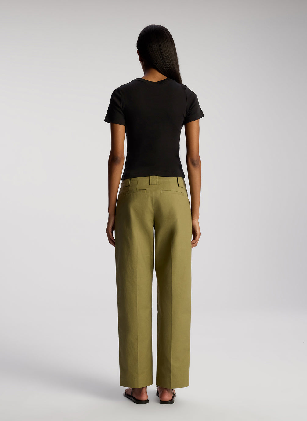 back view of woman wearing black tshirt and olive green pants
