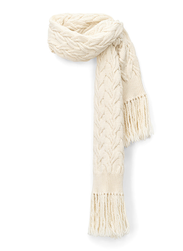 flat lay view of woman wearing cream cable knit scarf with fringe