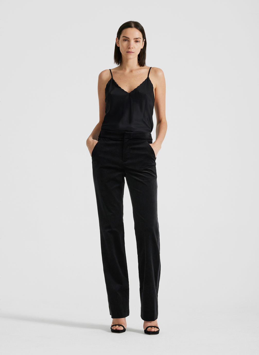 front view of woman wearing black satin camisole and black velvet pants