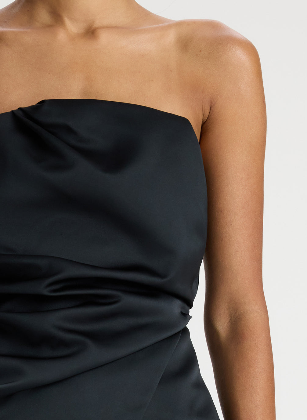detail  view of woman wearing black strapless satin top and black pants