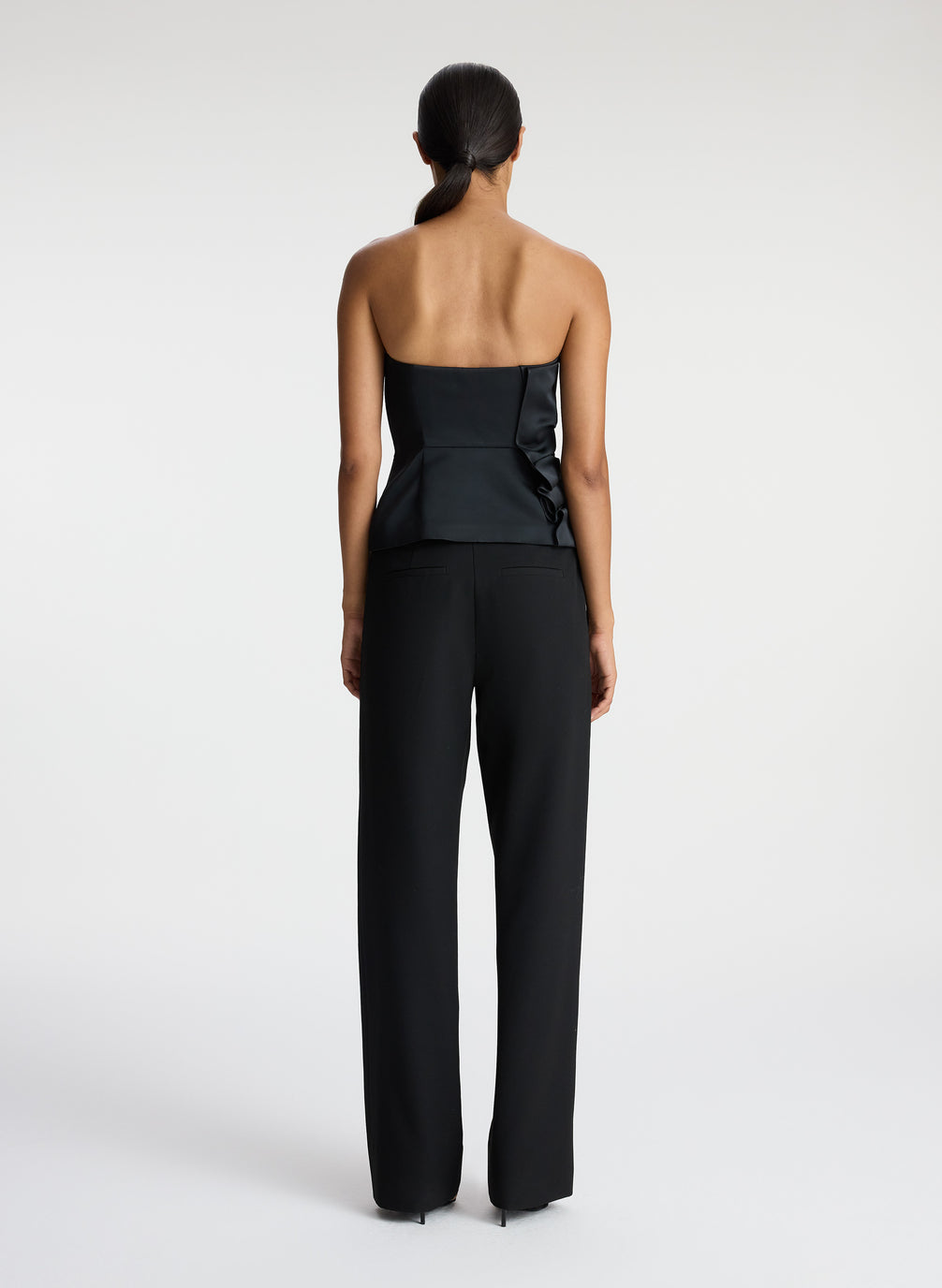 back  view of woman wearing black strapless satin top and black pants