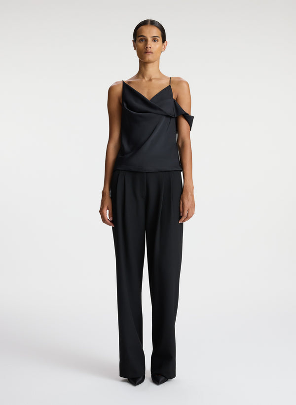 front view of woman wearing black satin asymmetric top with black pants