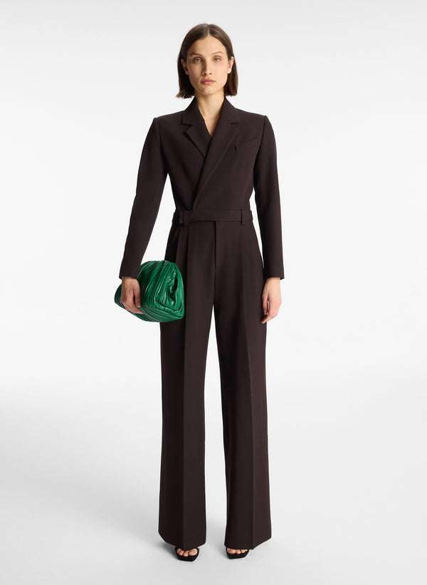 front view of woman wearing black long sleeve jumpsuit with back cutout