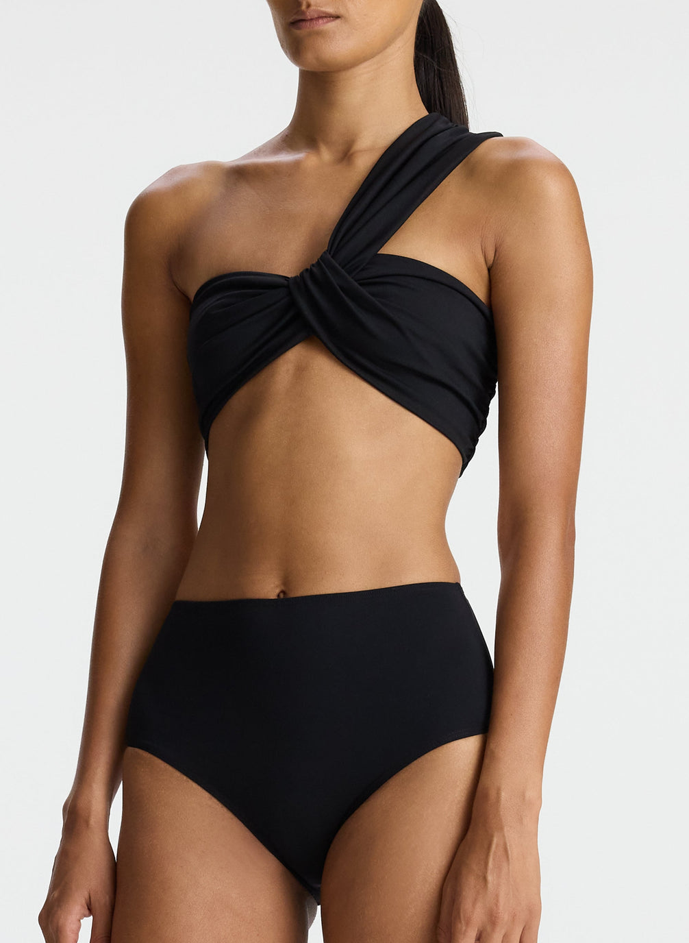 detail view of woman wearing black one shoulder swim top and black bikini bottom