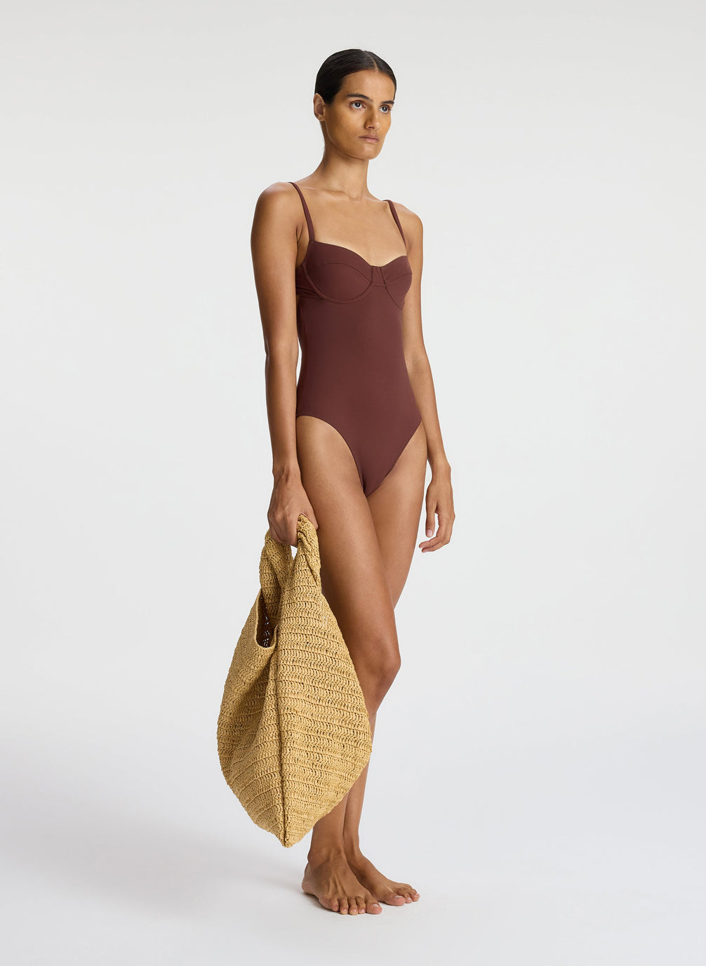 side view of woman wearing brown one piece swimsuit