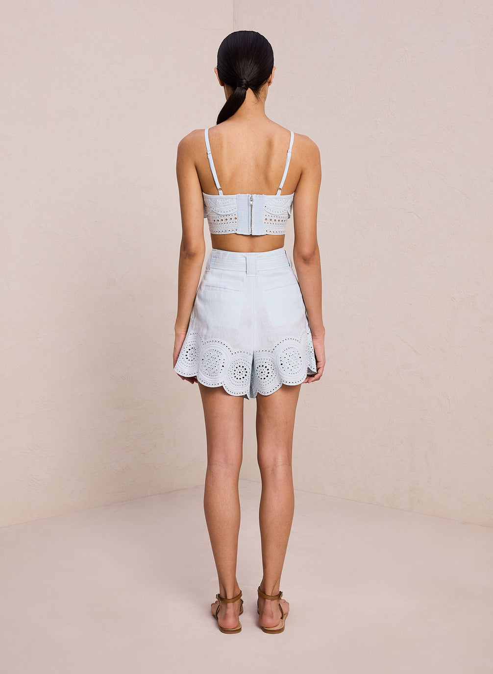back view of woman wearing light blue eyelet crop tank and coordinating short