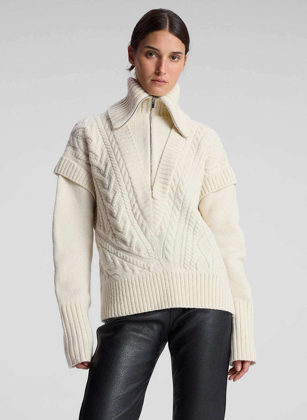 woman wearing cream cable knit sweater and black leather pant