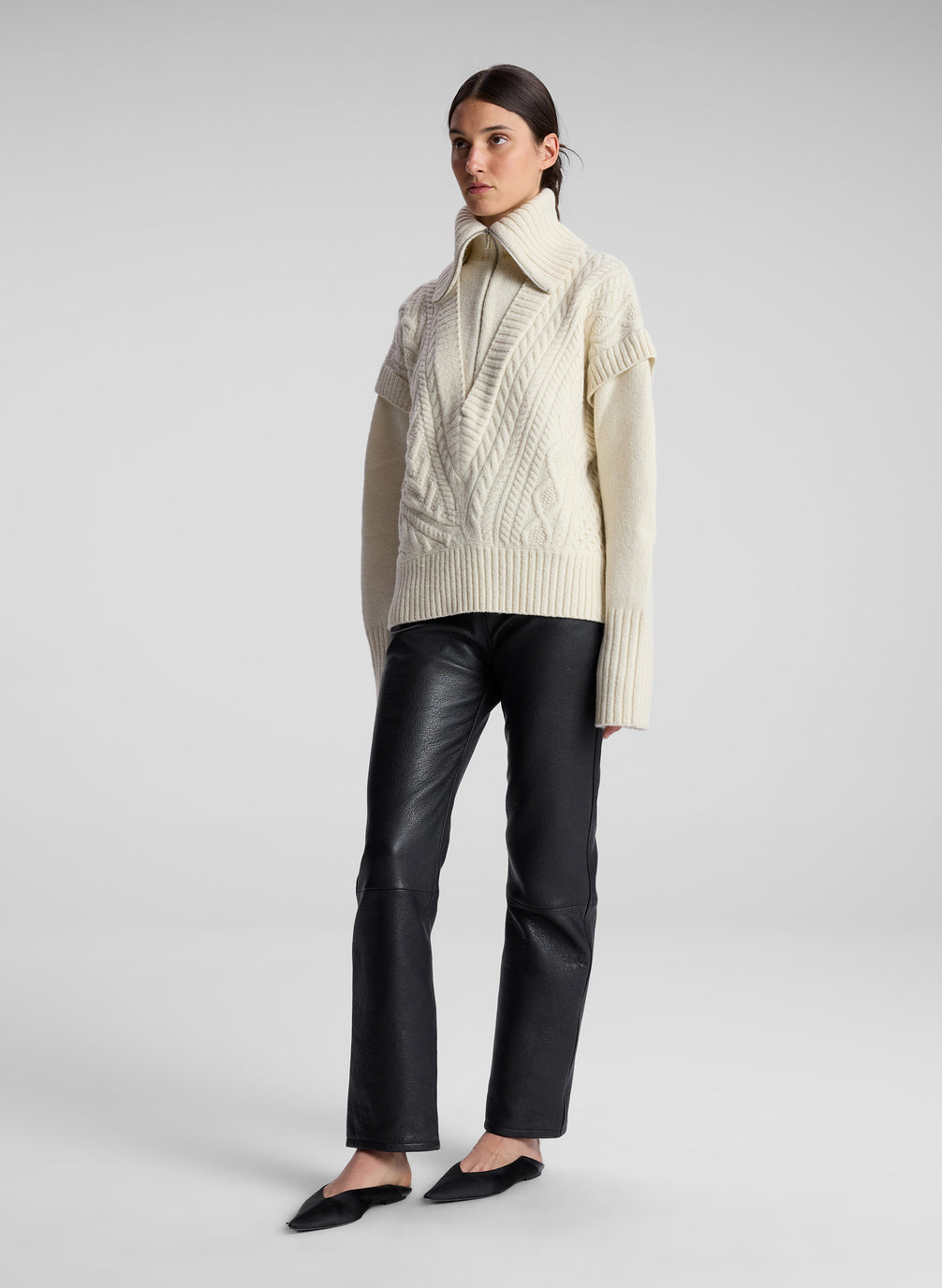 woman wearing cream cable knit sweater and black leather pant