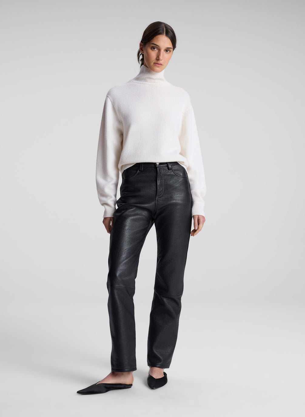 woman wearing cream sweater and black leather pants