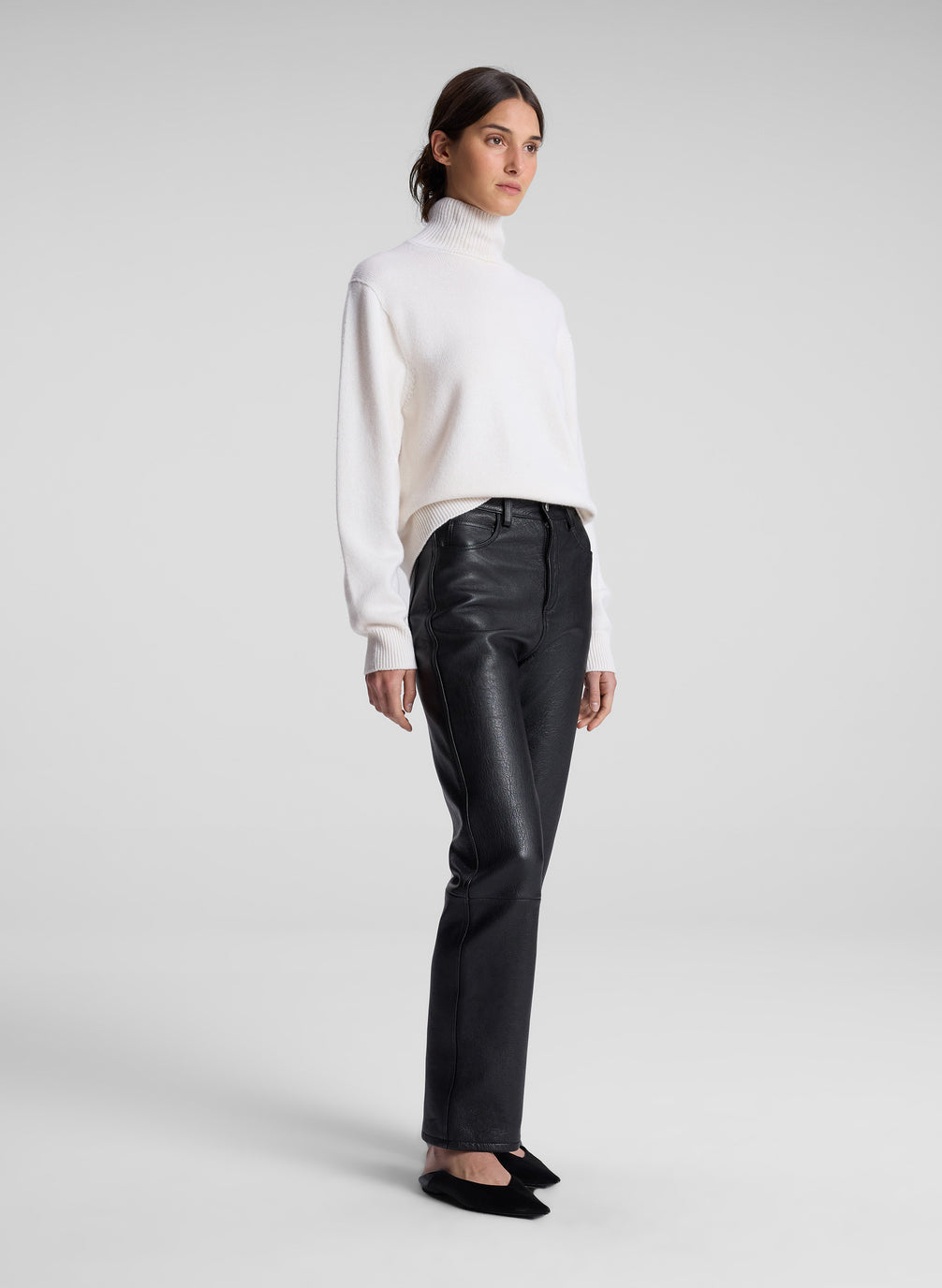 woman wearing cream sweater and black leather pants