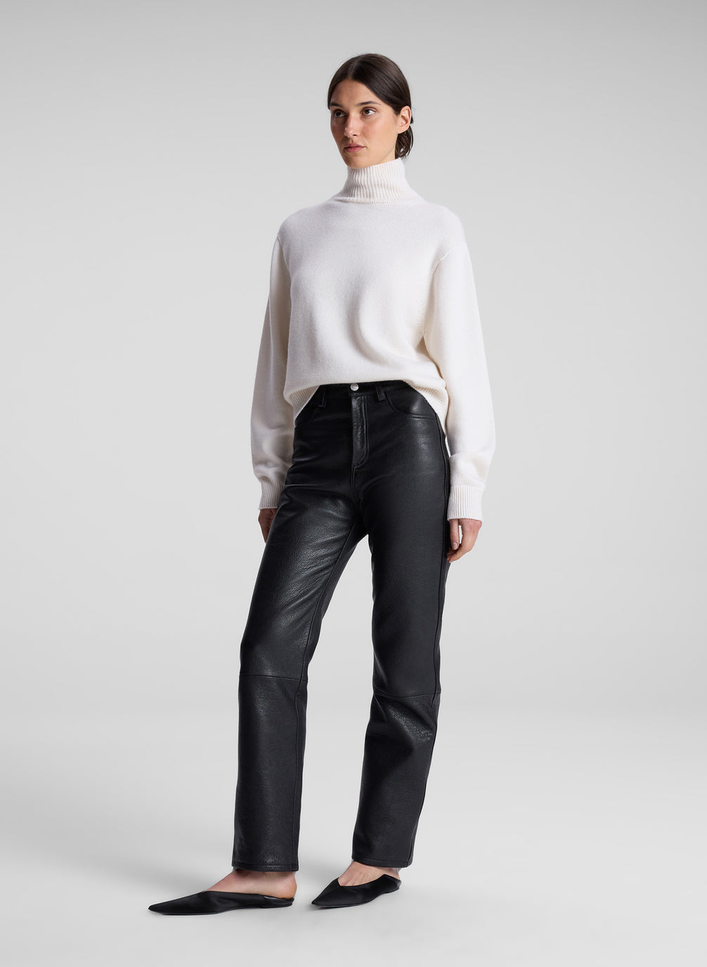 woman wearing cream sweater and black leather pants