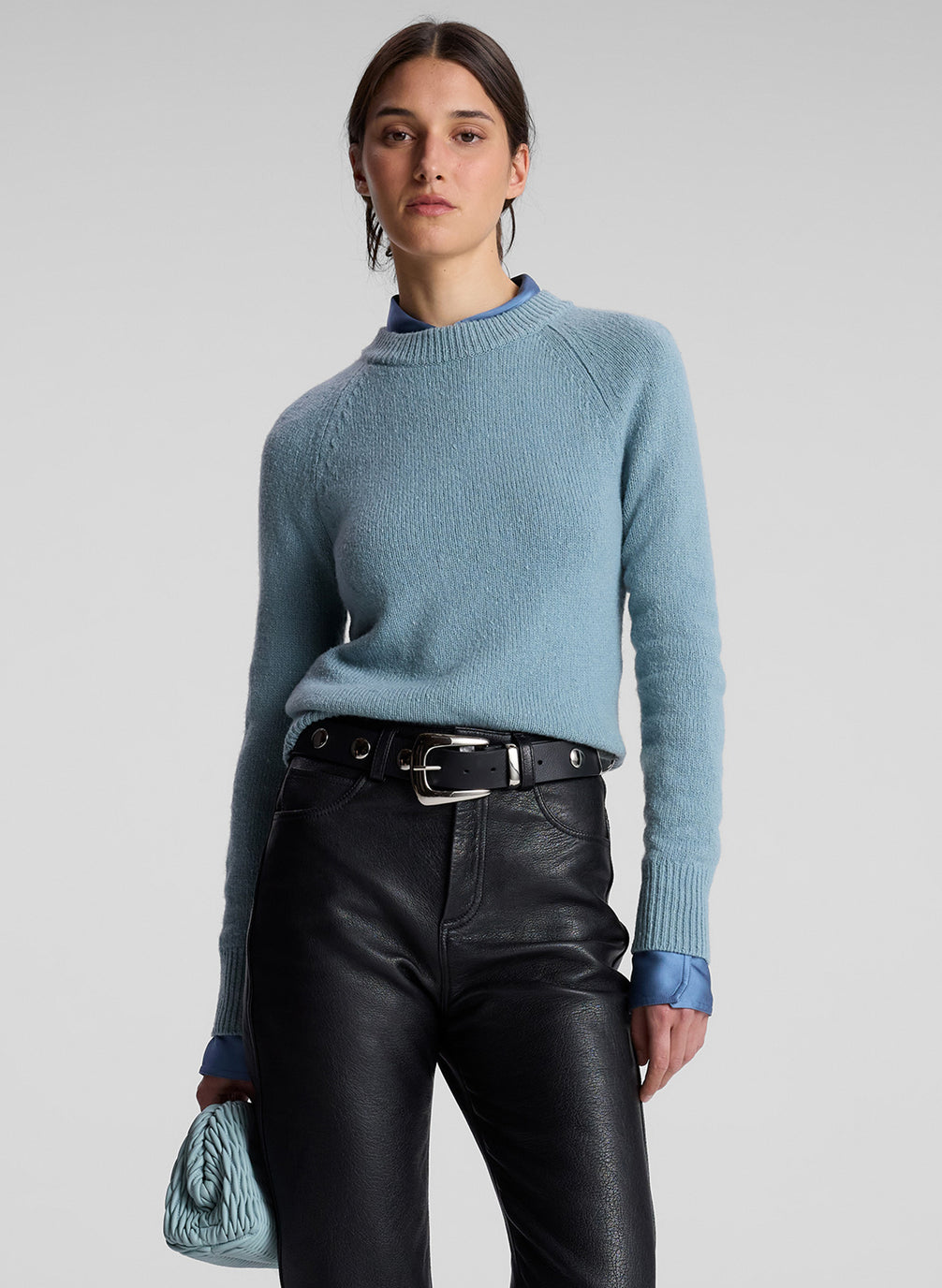 woman wearing blue sweater, blue shirt and black leather pants