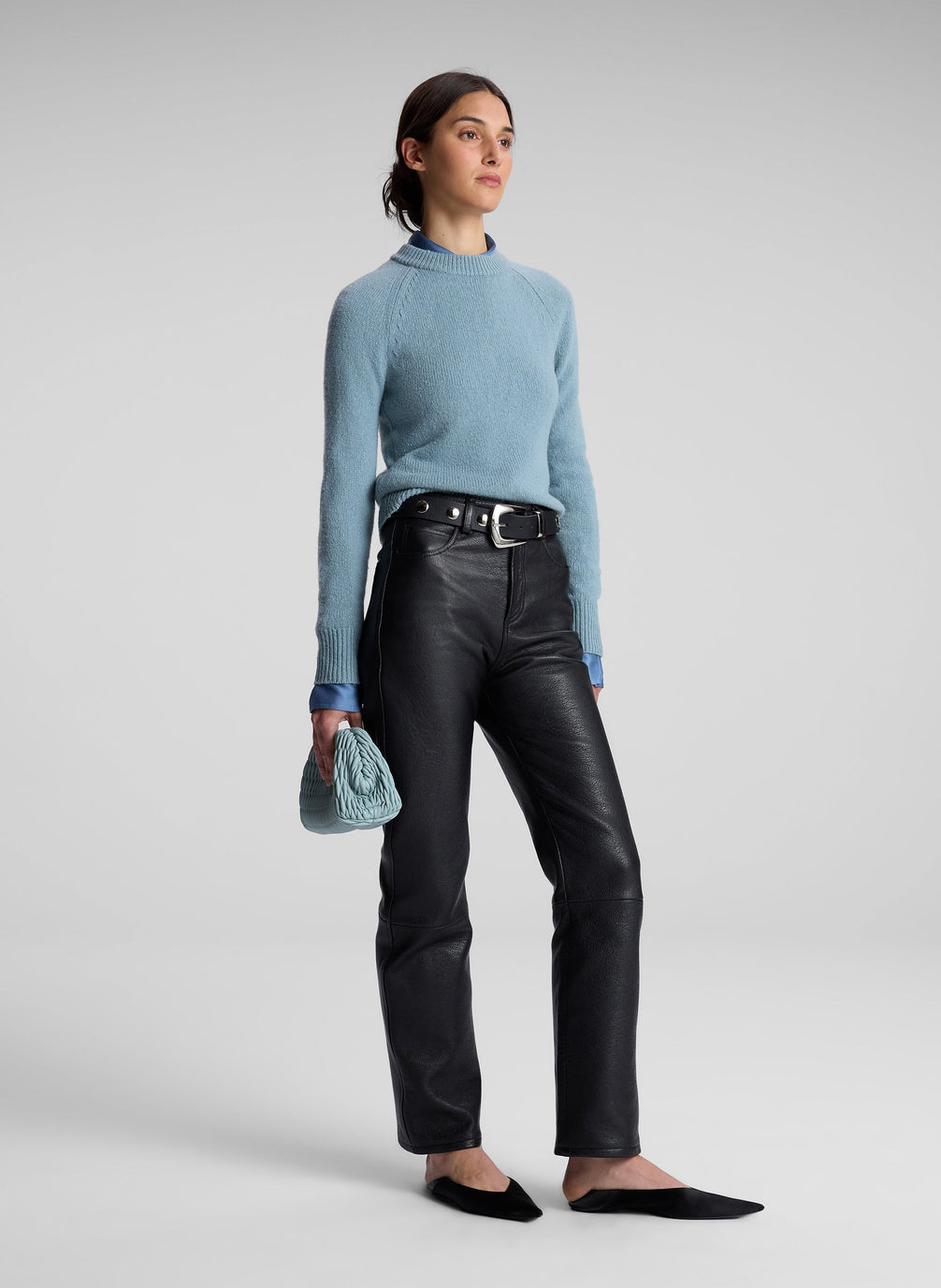 woman wearing blue sweater, blue shirt and black leather pants