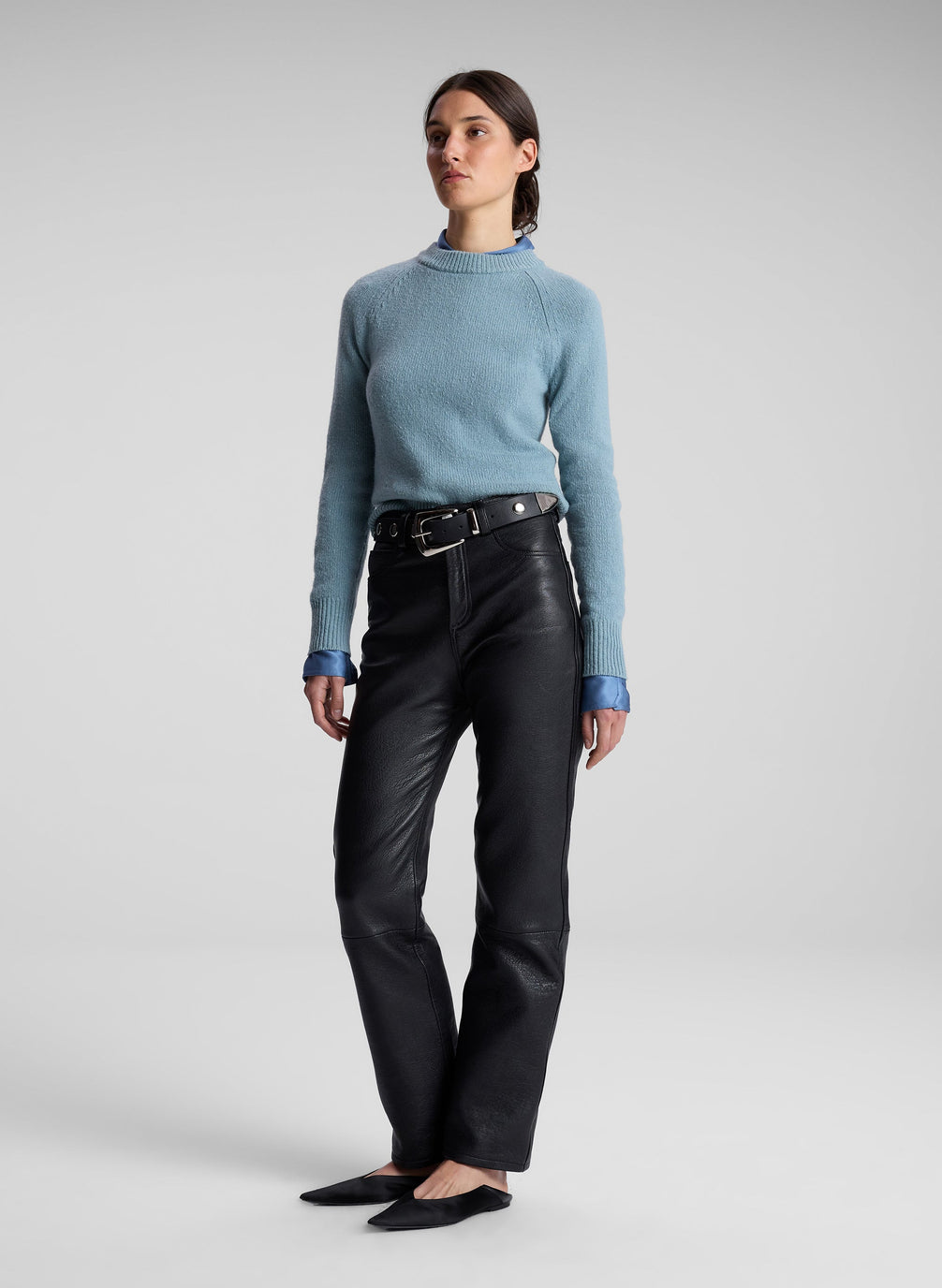 woman wearing blue sweater, blue shirt and black leather pants