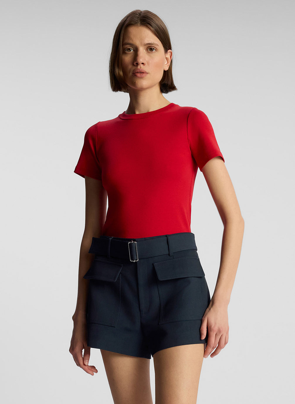 front view of woman wearing red t shirt and navy blue shorts