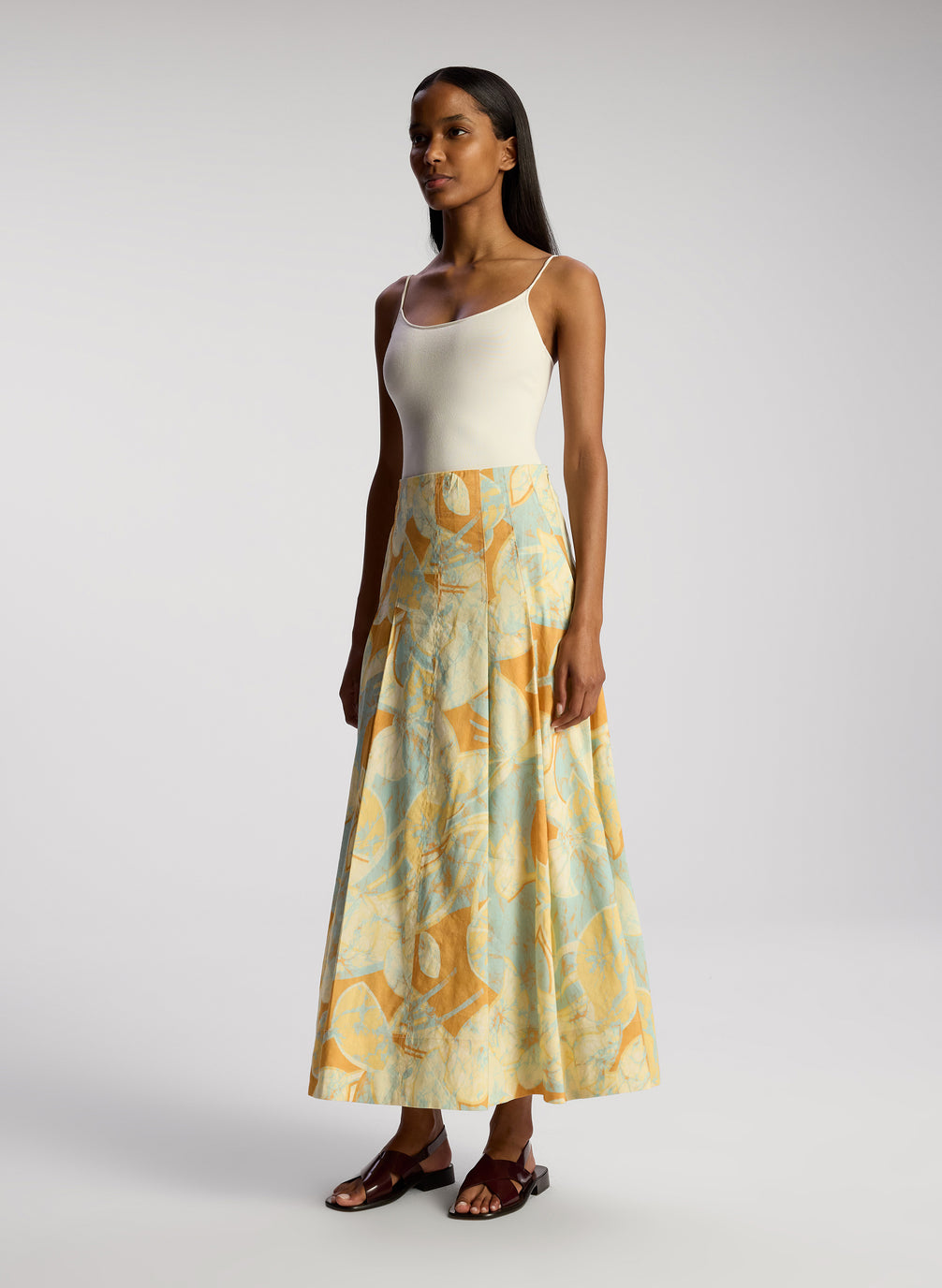 side view of woman wearing whit bodysuit and multicolor midi skirt