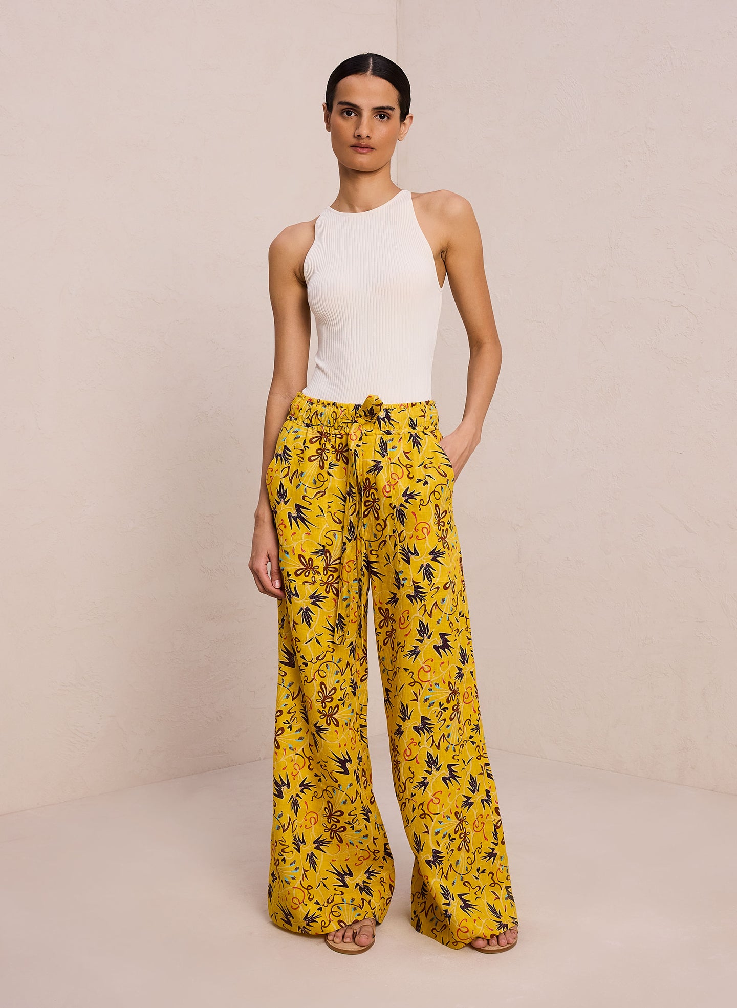 front view of woman wearing off white bodysuit and yellow printed wide leg pants