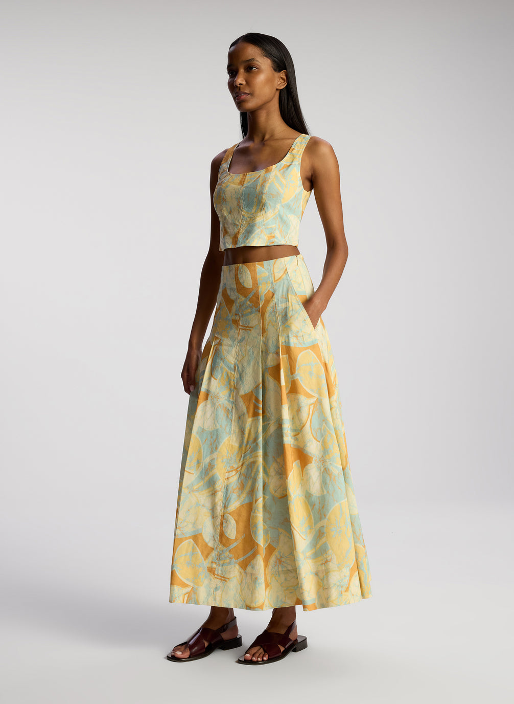 side view of woman wearing multicolor cropped sleeveless tops and matching midi skirt
