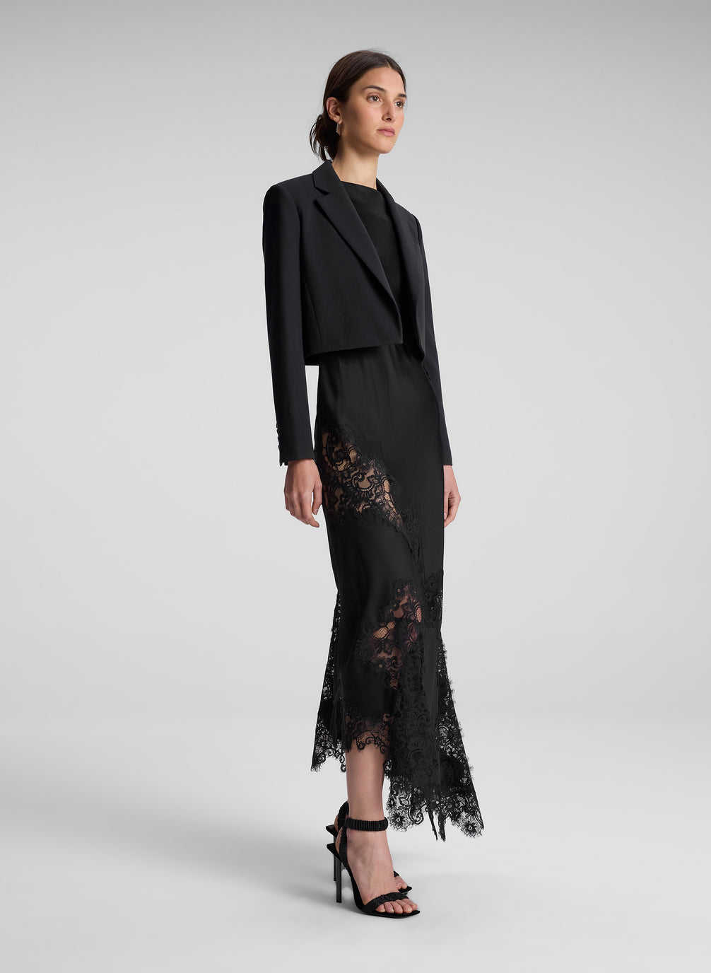 Woman wearing black cropped blazer and black lace dress