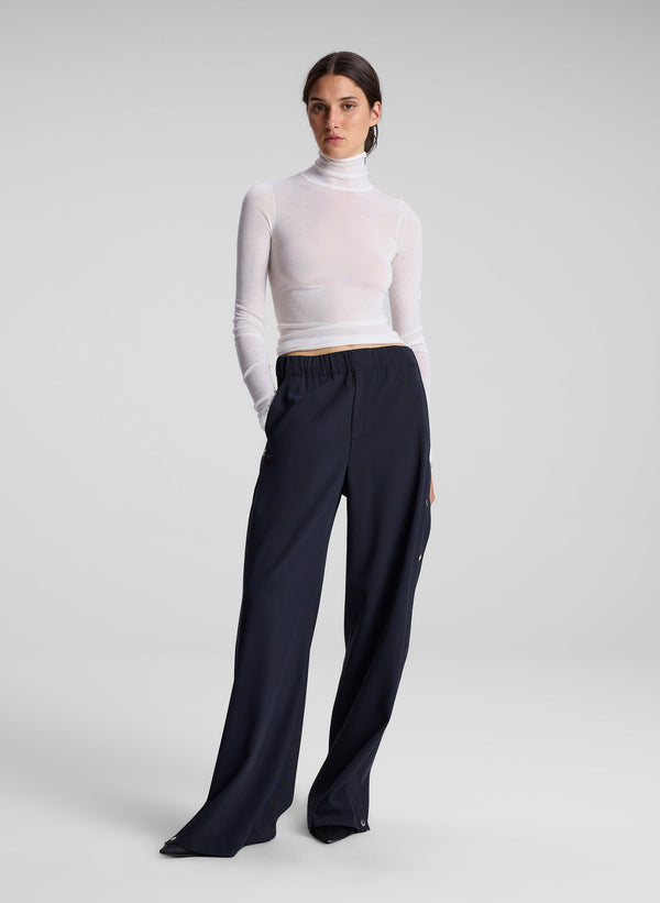 woman wearing white turtleneck top and black pants