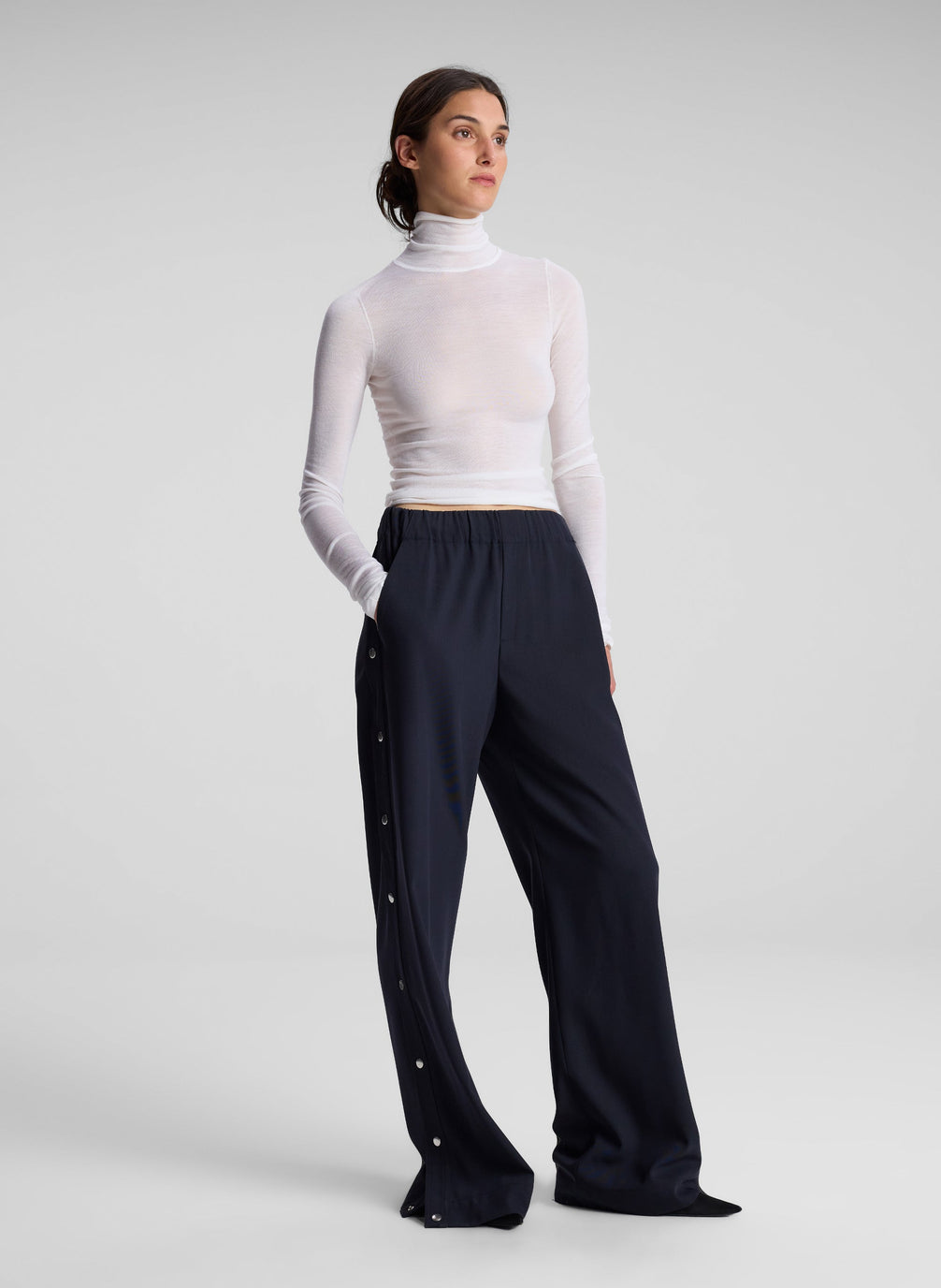 woman wearing white turtleneck top and black pants