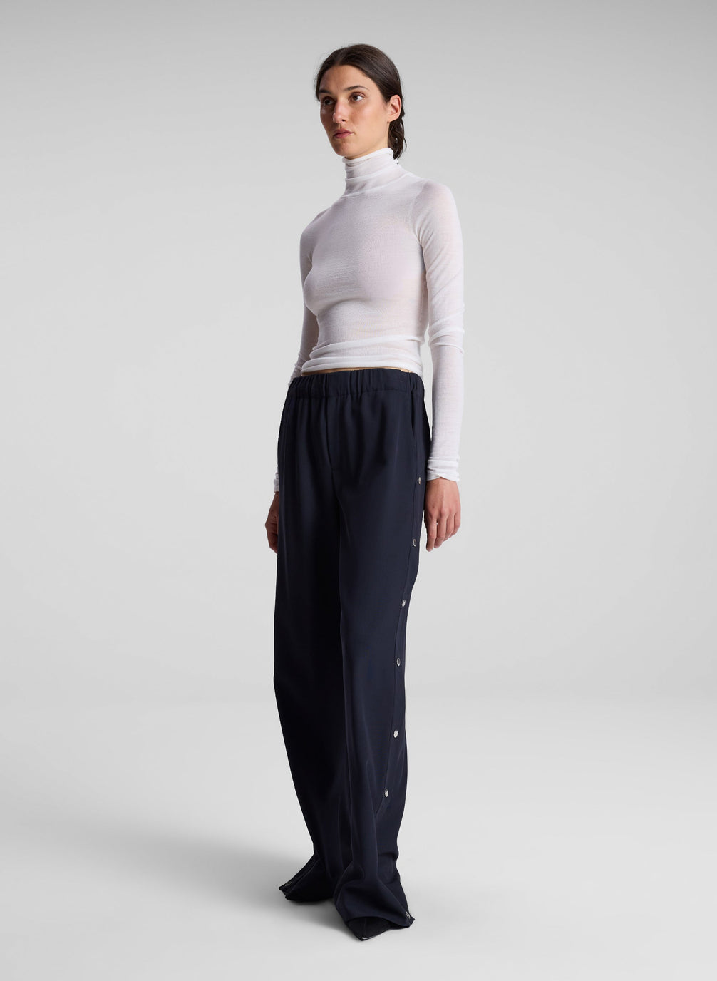 woman wearing white turtleneck top and black pants