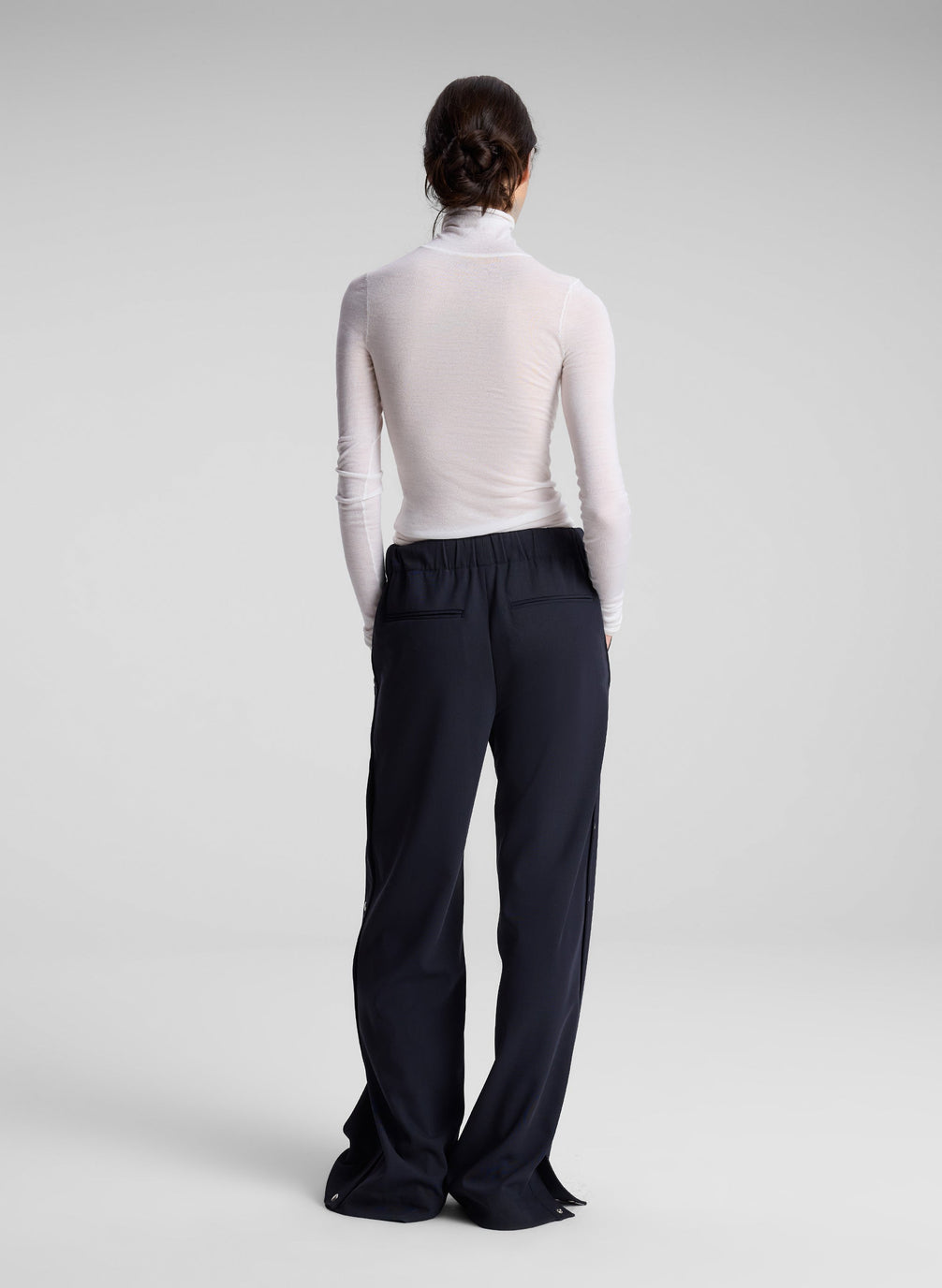 woman wearing white turtleneck top and black pants