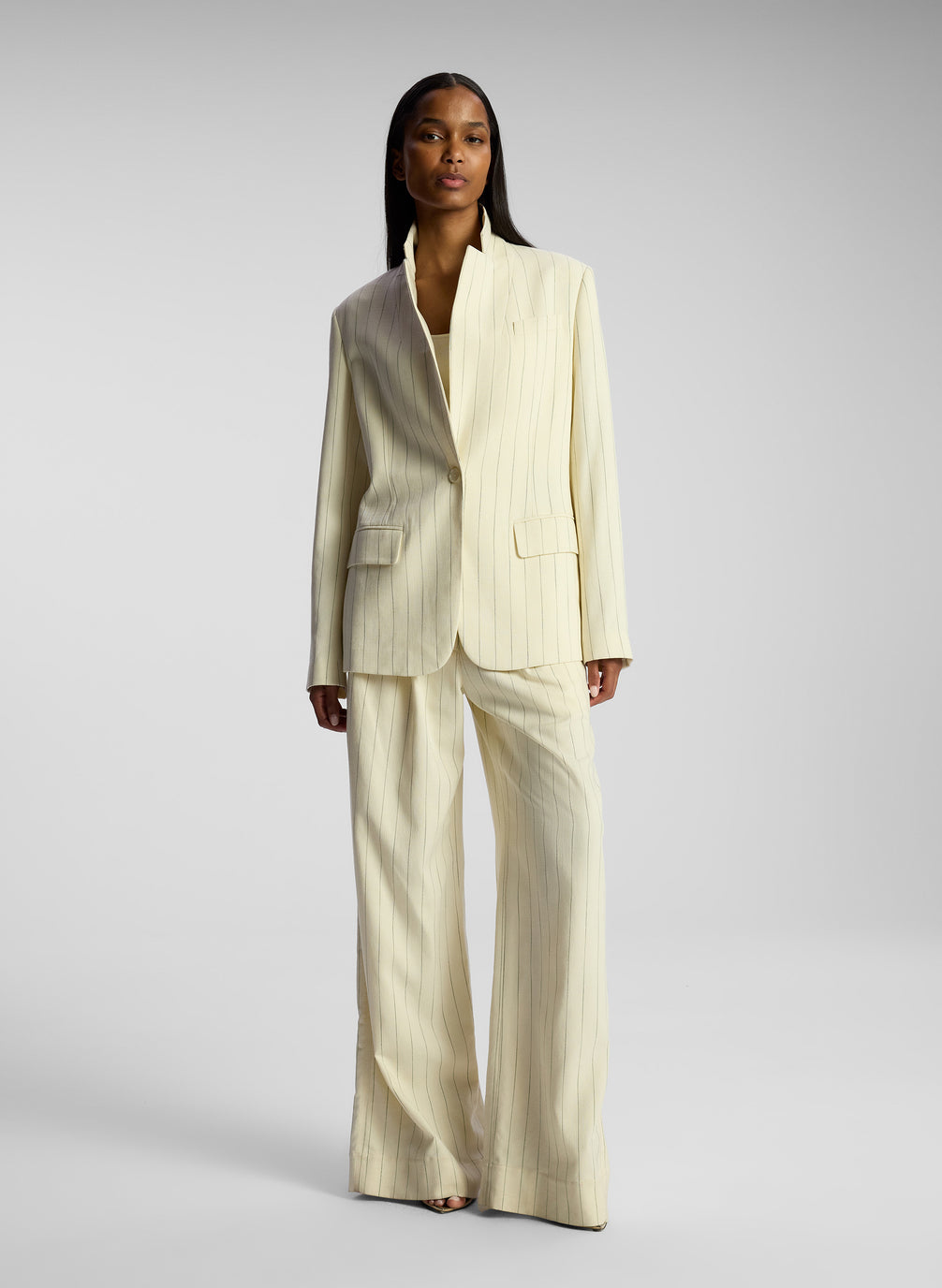 front view of woman wearing cream pinstripe suit