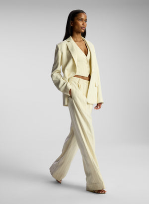 side view of woman wearing cream pinstriped suit