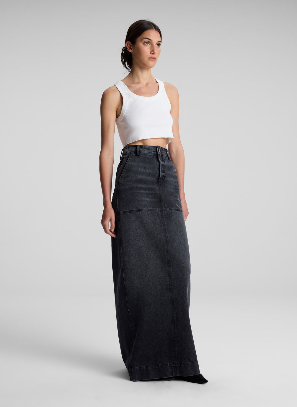 woman wearing white cropped tank and black denim maxi skirt