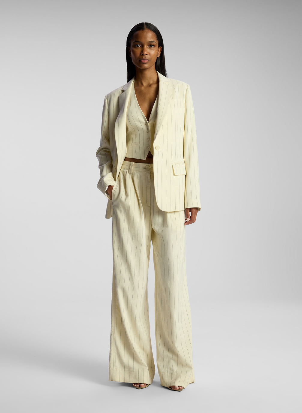 front view of woman wearing cream pinstripe suit