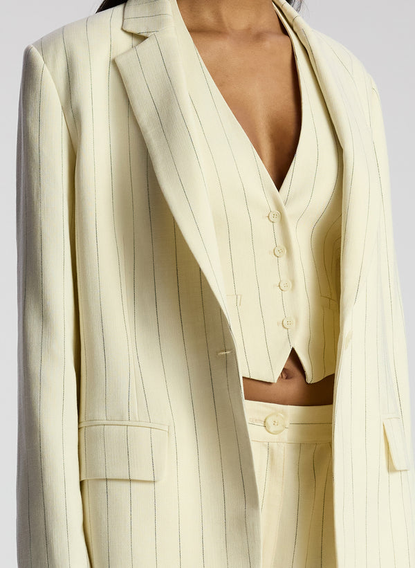 detail view of woman wearing cream pinstripe suit