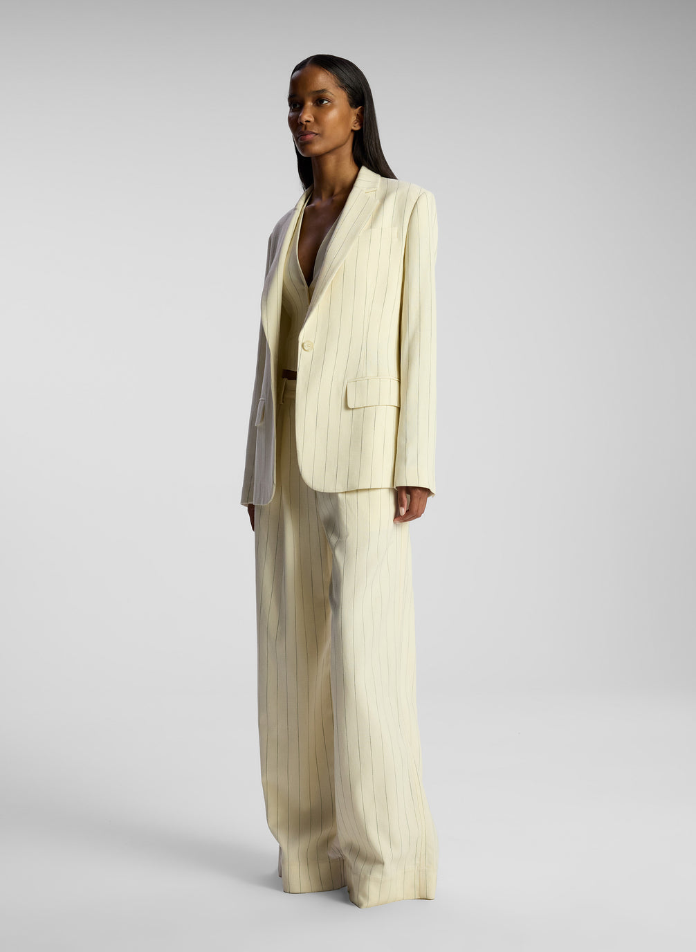 side view of woman wearing cream pinstripe suit