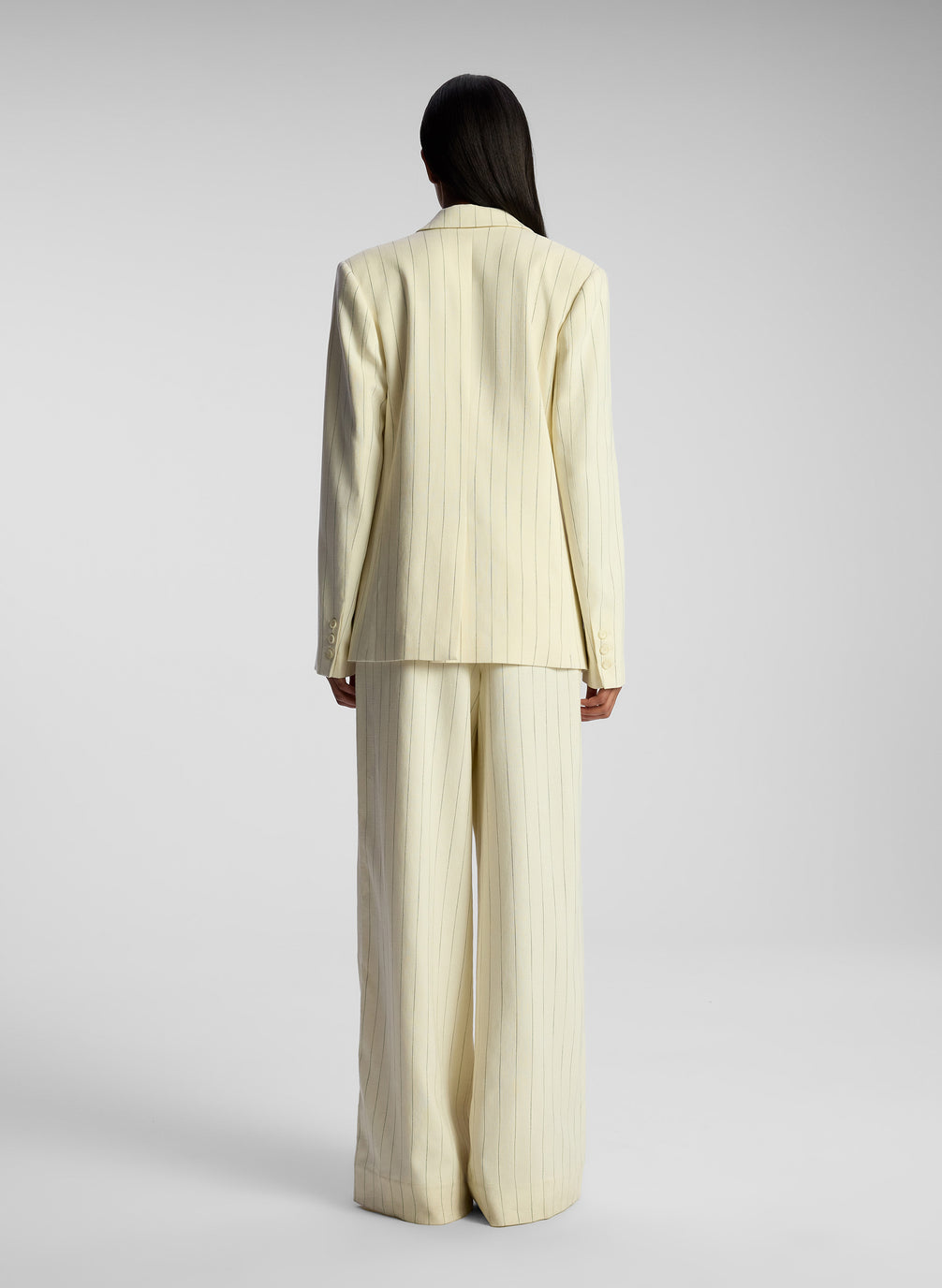 back view of woman wearing cream pinstripe suit