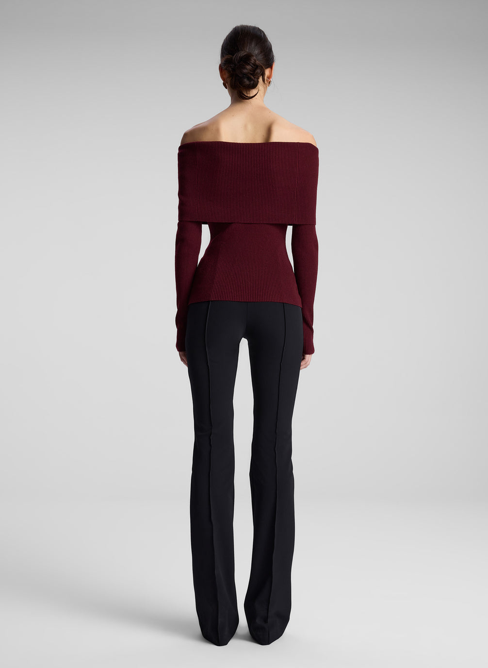 woman wearing off shoulder burgundy top and black pants