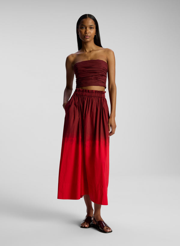 front view of woman wearing burgundy and red ombre top and skirt