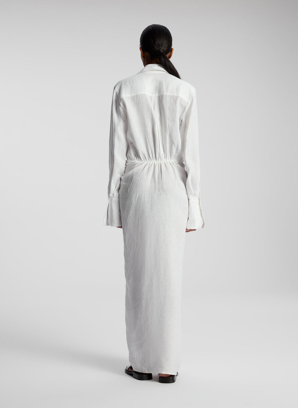 back view of woman wearing white linen maxi shirtdress
