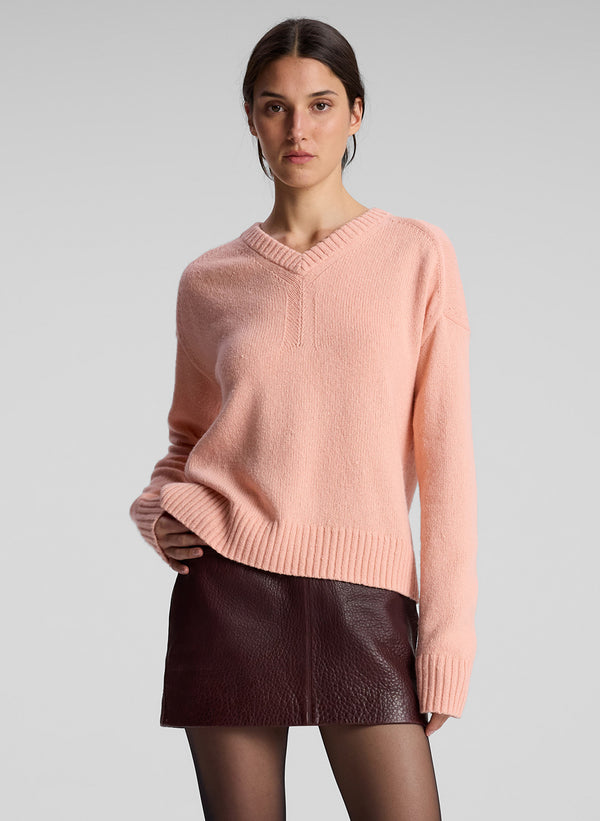 woman wearing peach sweater and maroon miniskirt