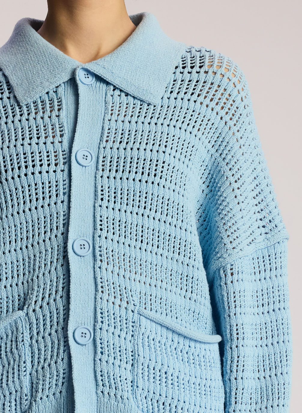 detail view of woman wearing light blue cardigan and matching shorts