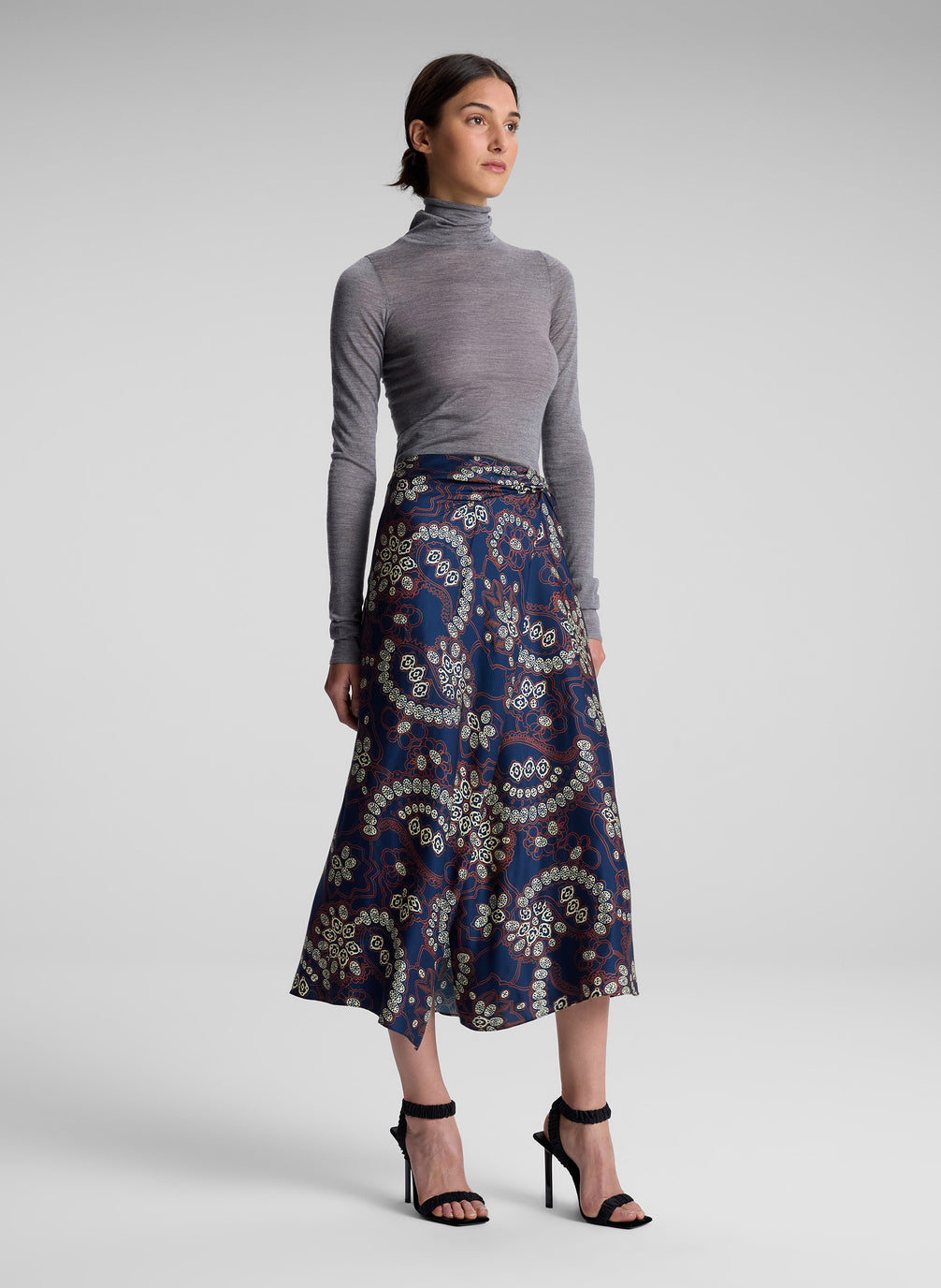 woman wearing grey turtleneck and floral midi skirt