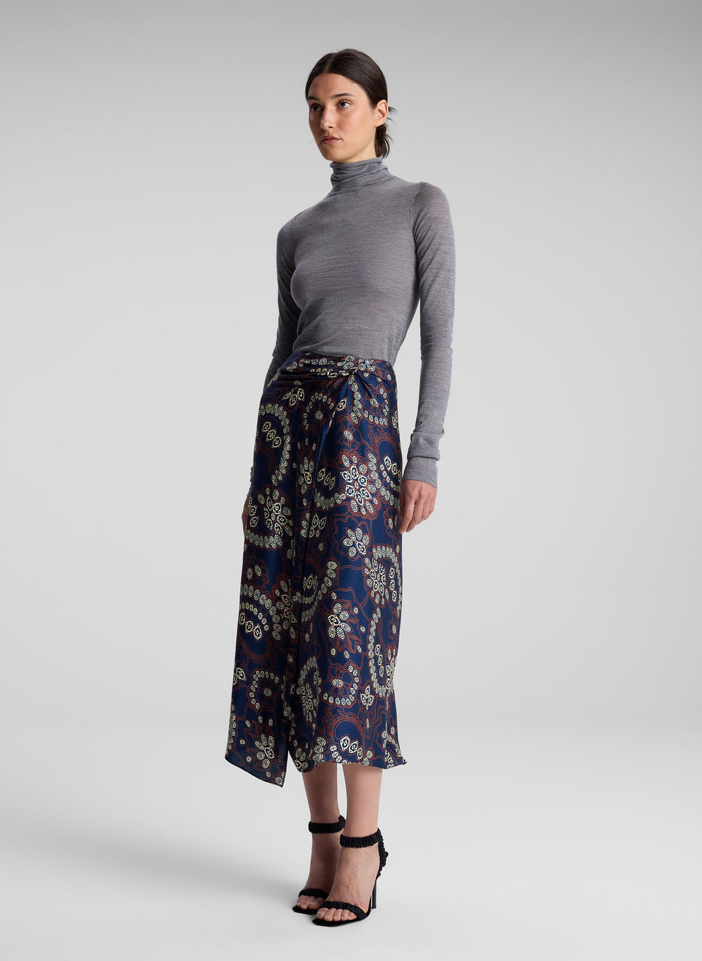 woman wearing grey turtleneck and floral midi skirt