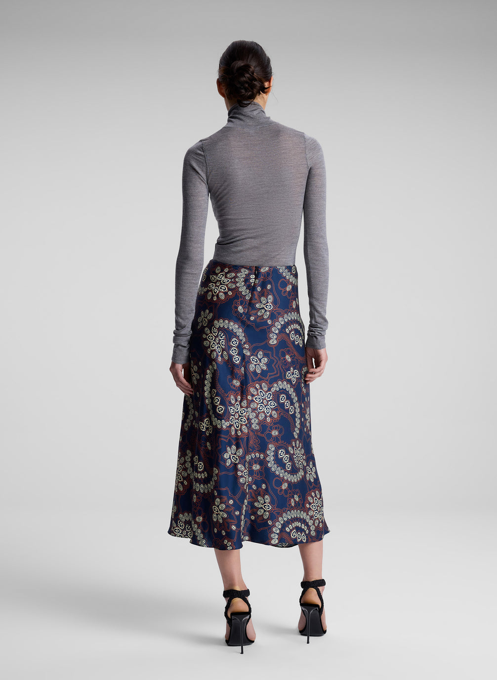 woman wearing grey turtleneck and floral midi skirt