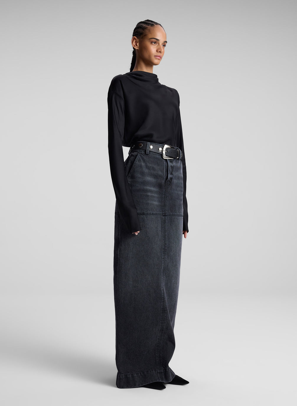 woman wearing black top and black denim maxi skirt