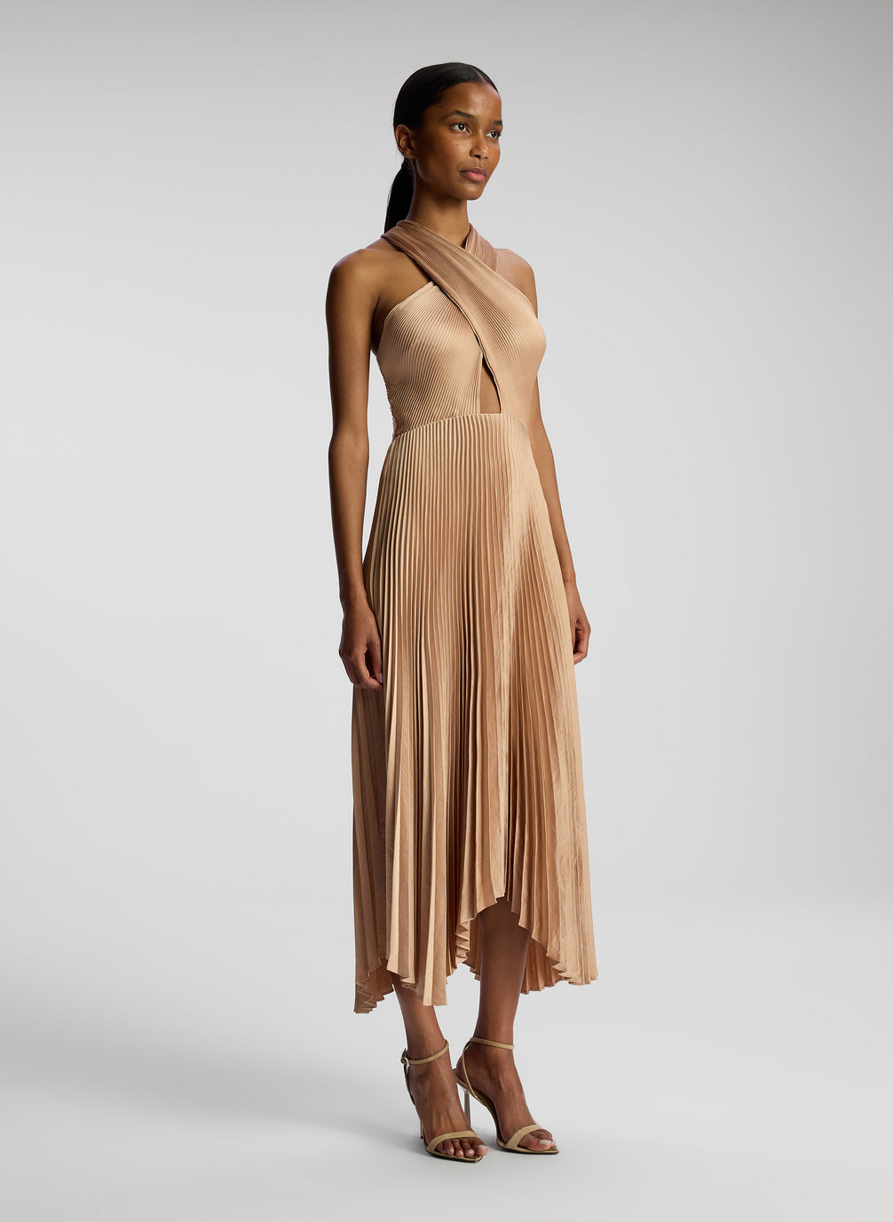 side view of woman wearing blush colored pleated midi dress