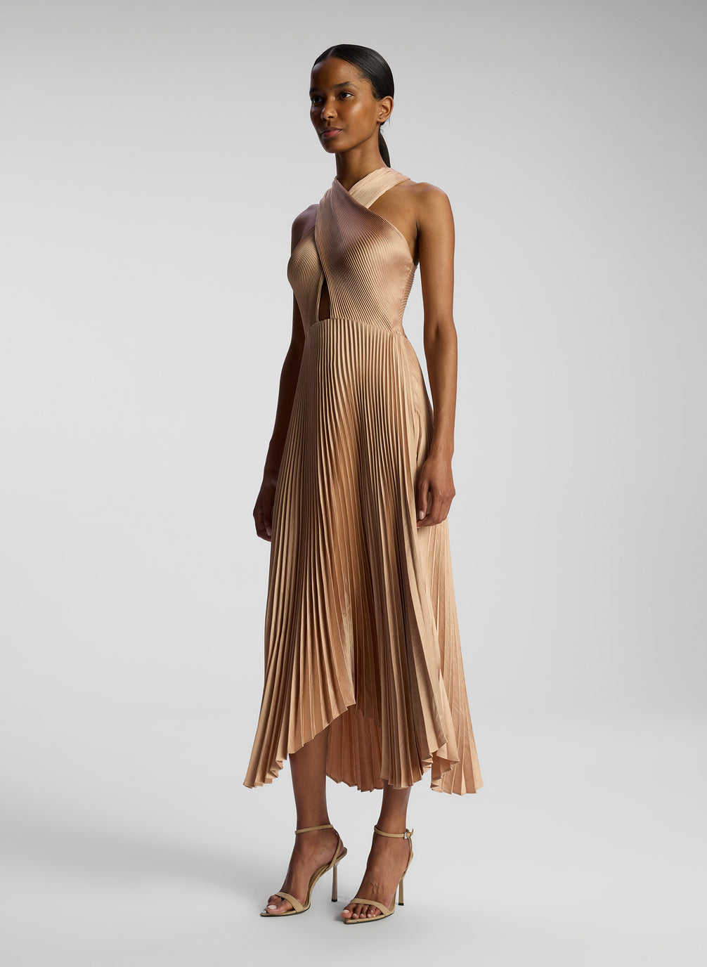 side view of woman wearing blush colored pleated midi dress